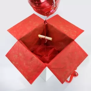 karton z balonikiem jest udekorowany czerwoną flizeliną