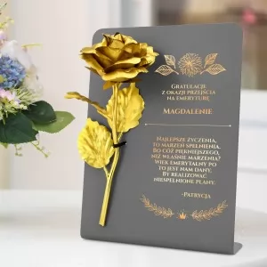 złota róża wieczna na postumencie z grawerem dedykacji dla emeryta