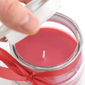 czerwona świeczka zapachowa ze wstążką na prezent